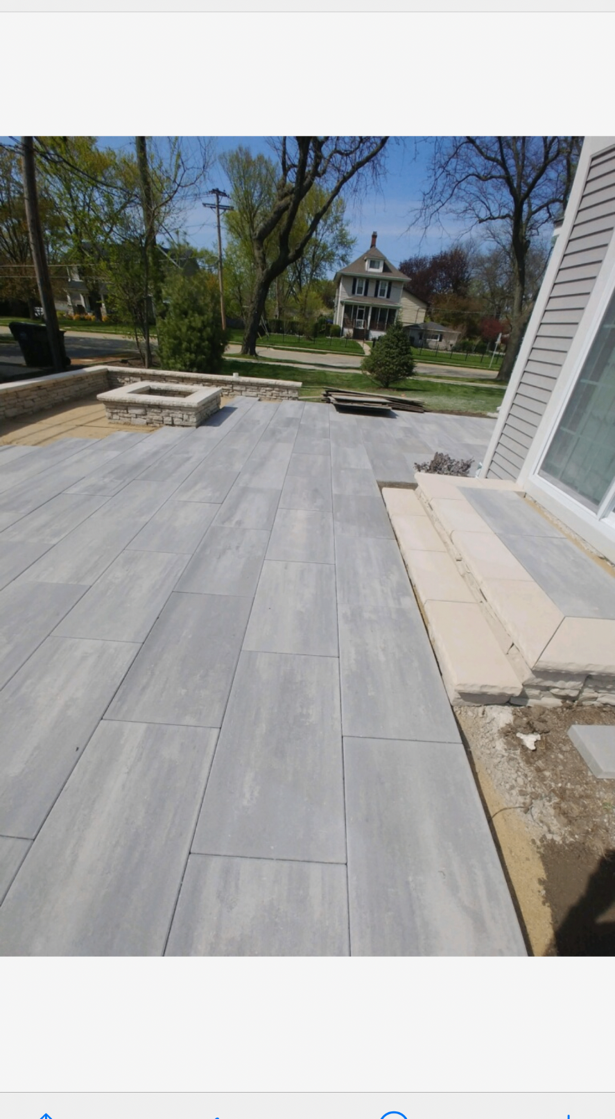 Large-format stone patio installed beside a home