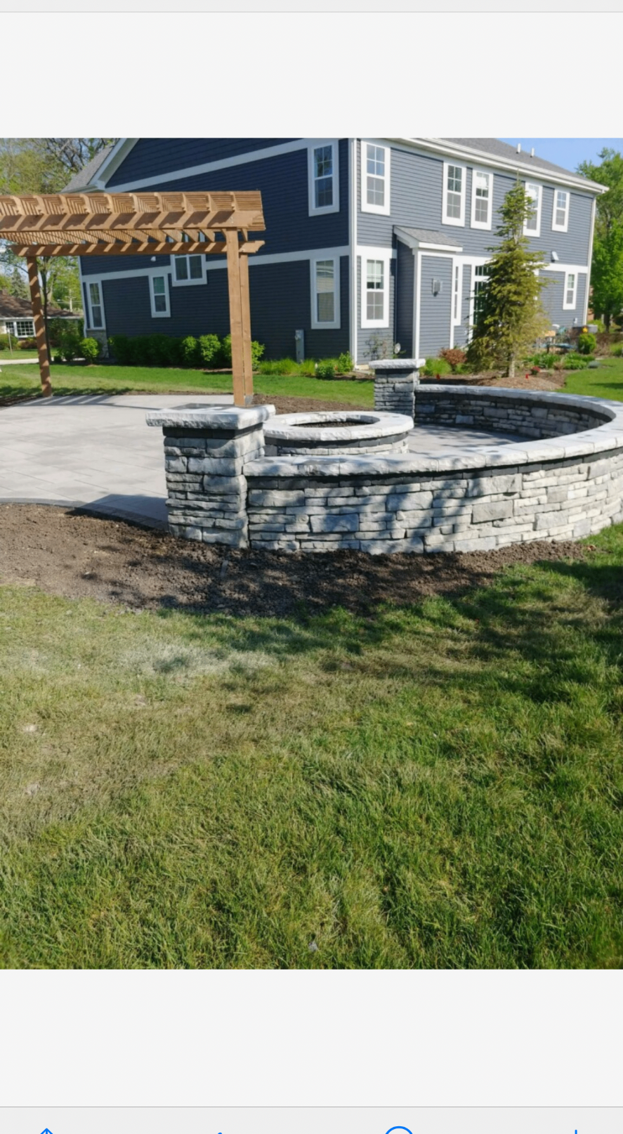 Outdoor living area with stone seat wall and pergola